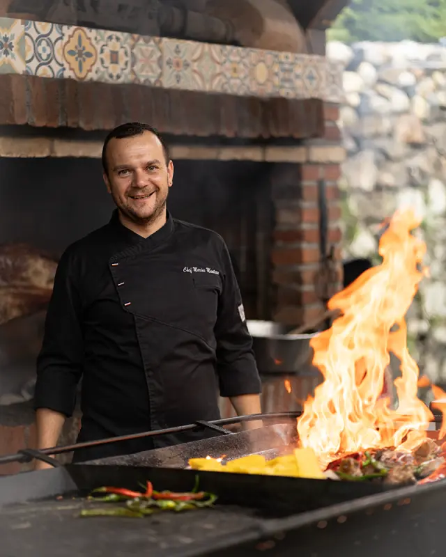 Outdoor-Branding-Foto eines Kochs in Sibiu beim Grillen über offenem Feuer, eine Kombination aus traditioneller Kochweise und starker Bildwirkung.